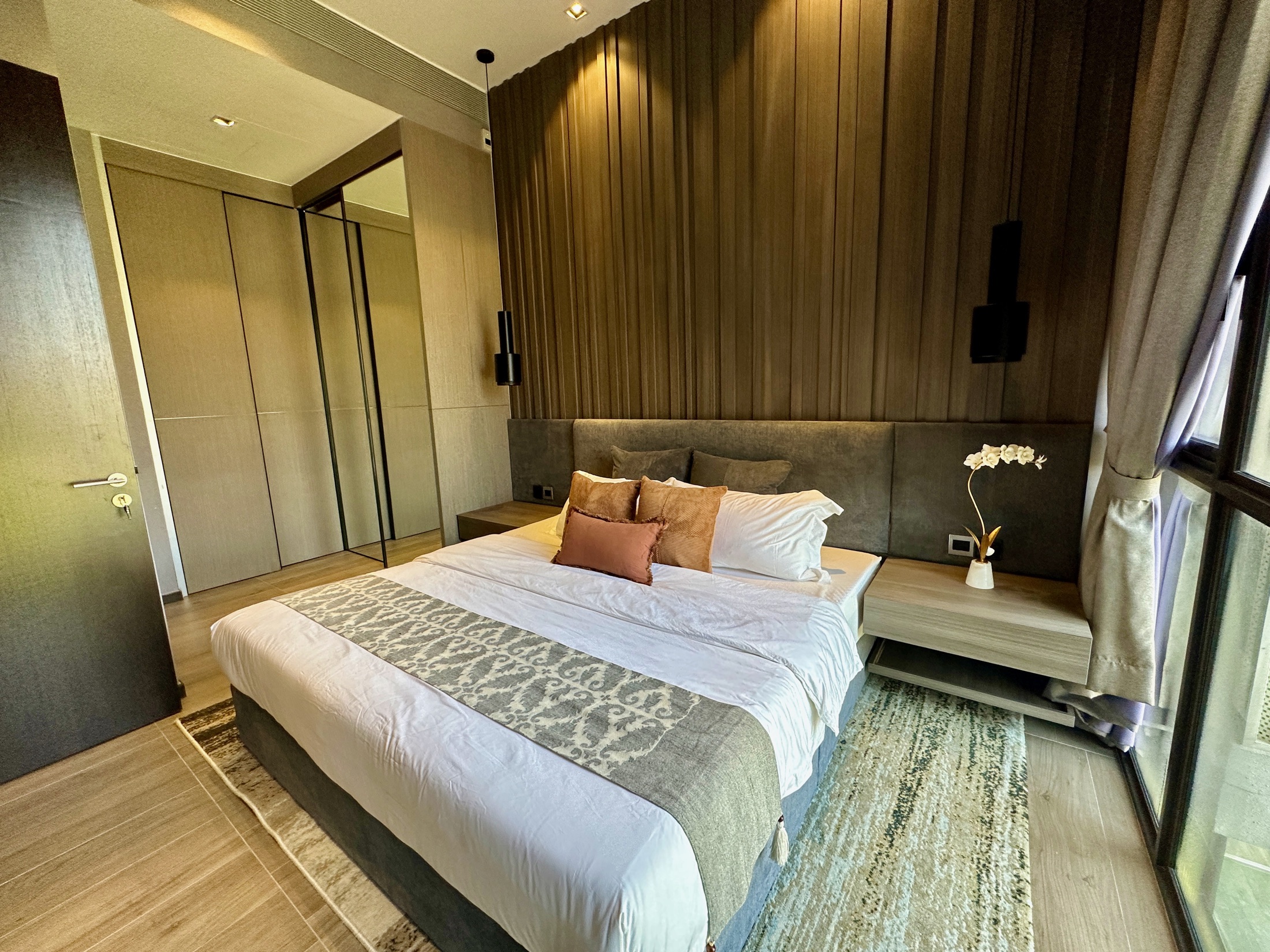 Renovated bedroom at The Siena with warm feature wall and full-height wardrobe