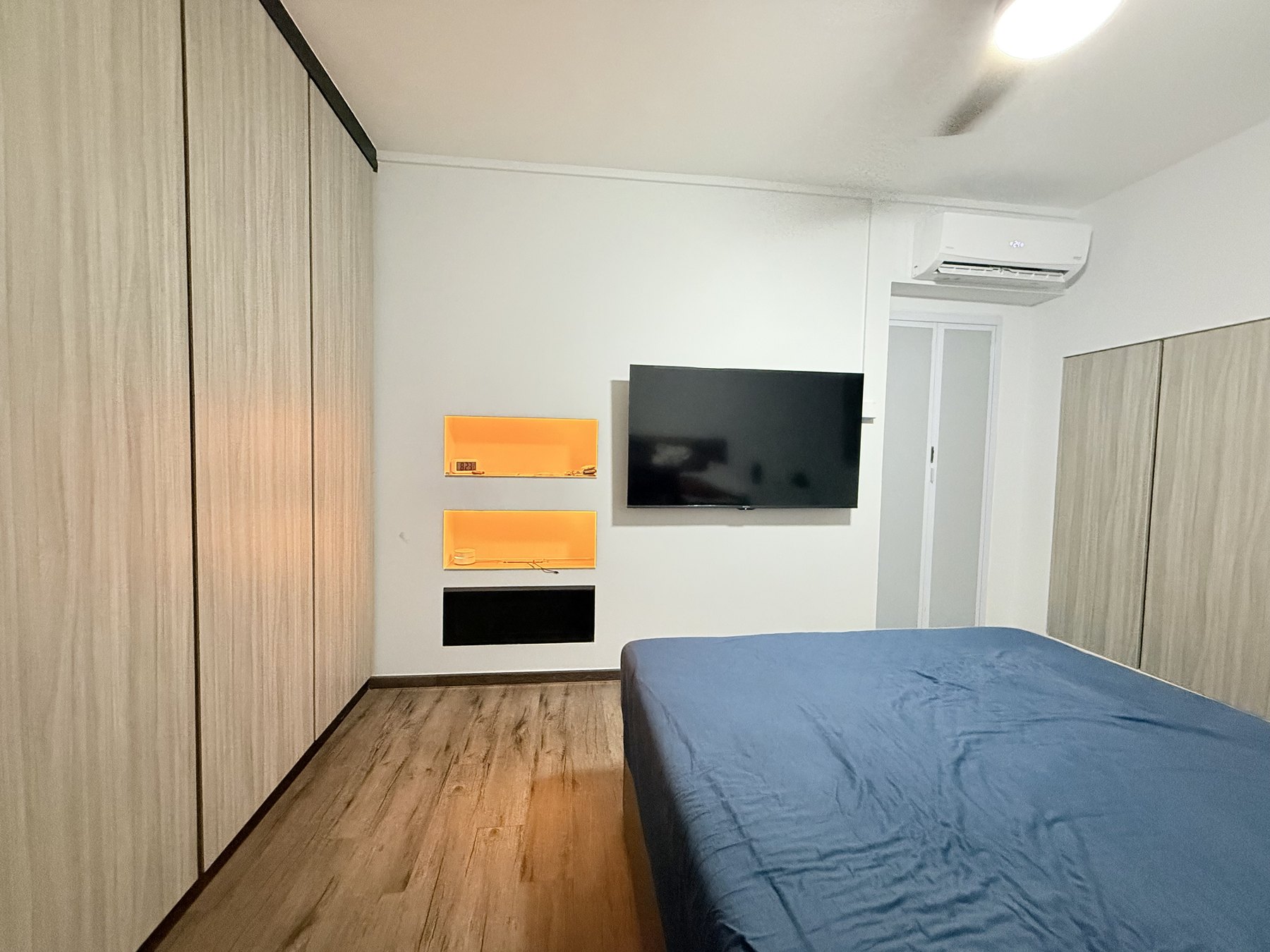 Bedroom in the Toa Payoh HDB flat with built-in wardrobe and TV wall